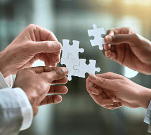 Hands joining puzzle pieces to depict connectivity and integration with external agents