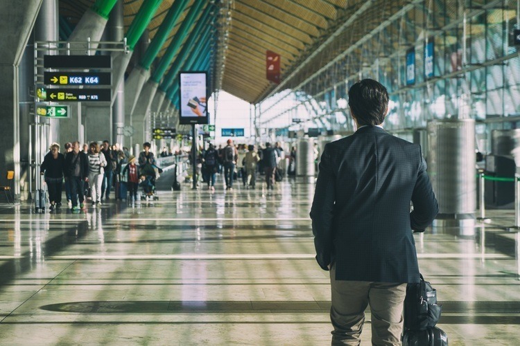 A passenger with luggage walking through an airport-1