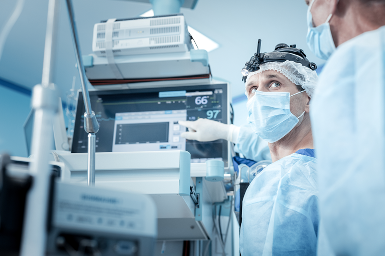 Connected healthcare devices - A male doctor indicating a reading on a computer screen and showing it to a female doctor