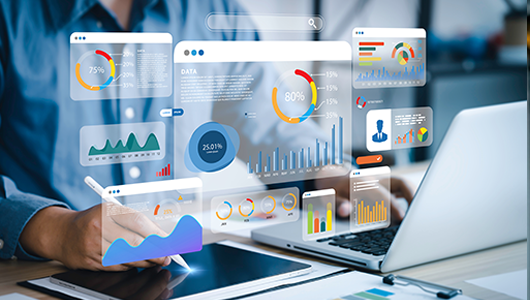 A user interacting with a laptop, with various data visualization and charts.