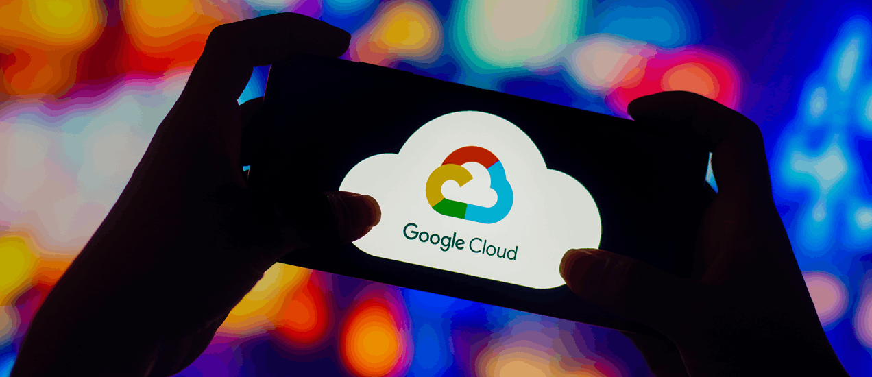 Smartphone displaying the Google Cloud logo held against a colorful, abstract digital background.