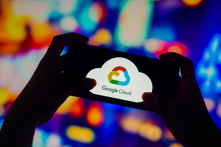 Smartphone displaying the Google Cloud logo held against a colorful, abstract digital background.