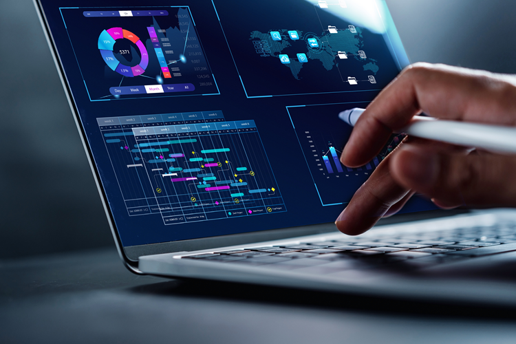 Hand of a person analyzing data on a laptop depicting hotel overview data analysis