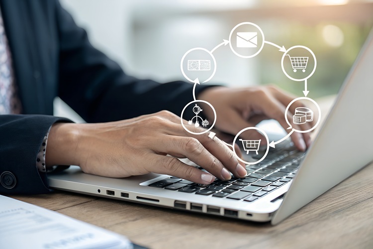 Hands of a person working on laptop with order processing icons in the foreground