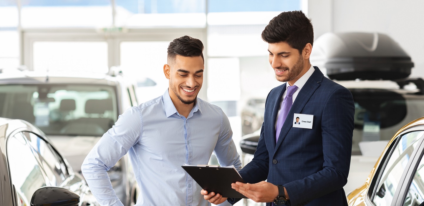 Man at a car dealership banner