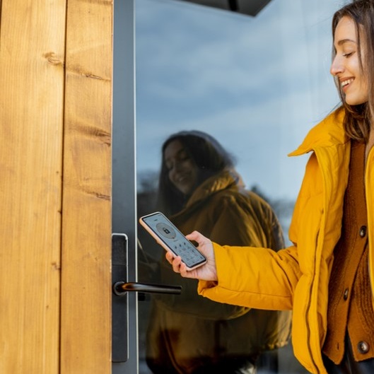 A woman unlocking a smart lock using her phone