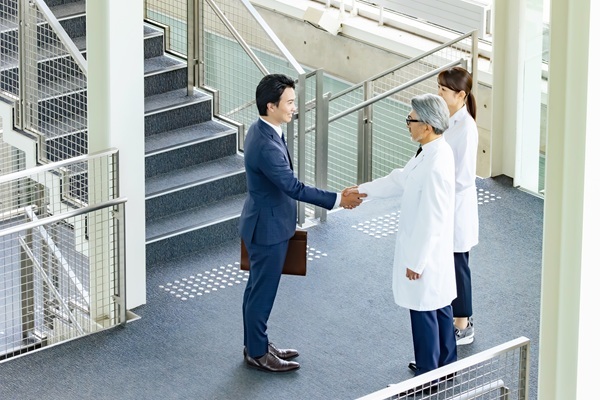 Scientists shaking hands with business professional