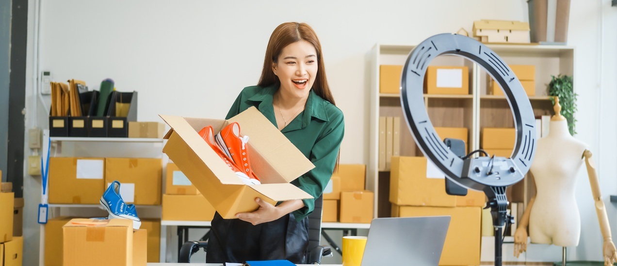 A woman holding a shoe box and showing it on a live stream on social media platforms.