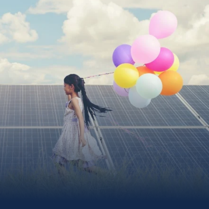 A girl with balloons in her hand standing beside solar panels