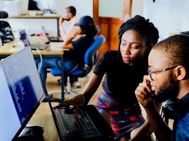 two techies looking at laptop for code review